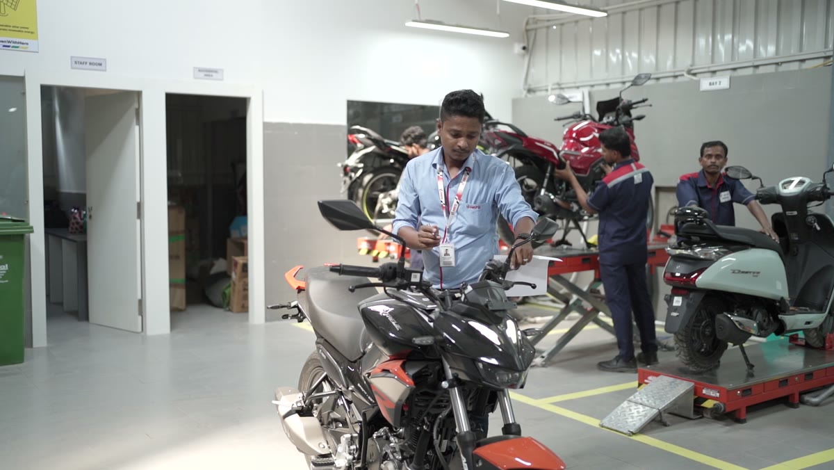 Advisor moving a bike into a bay